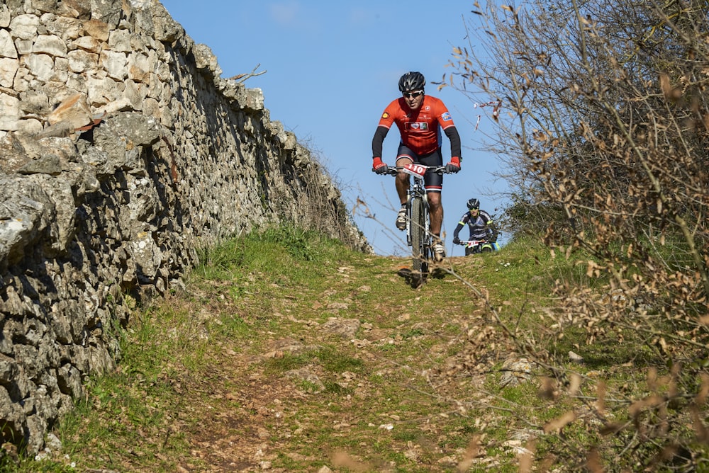 a man riding a bike down a dirt road