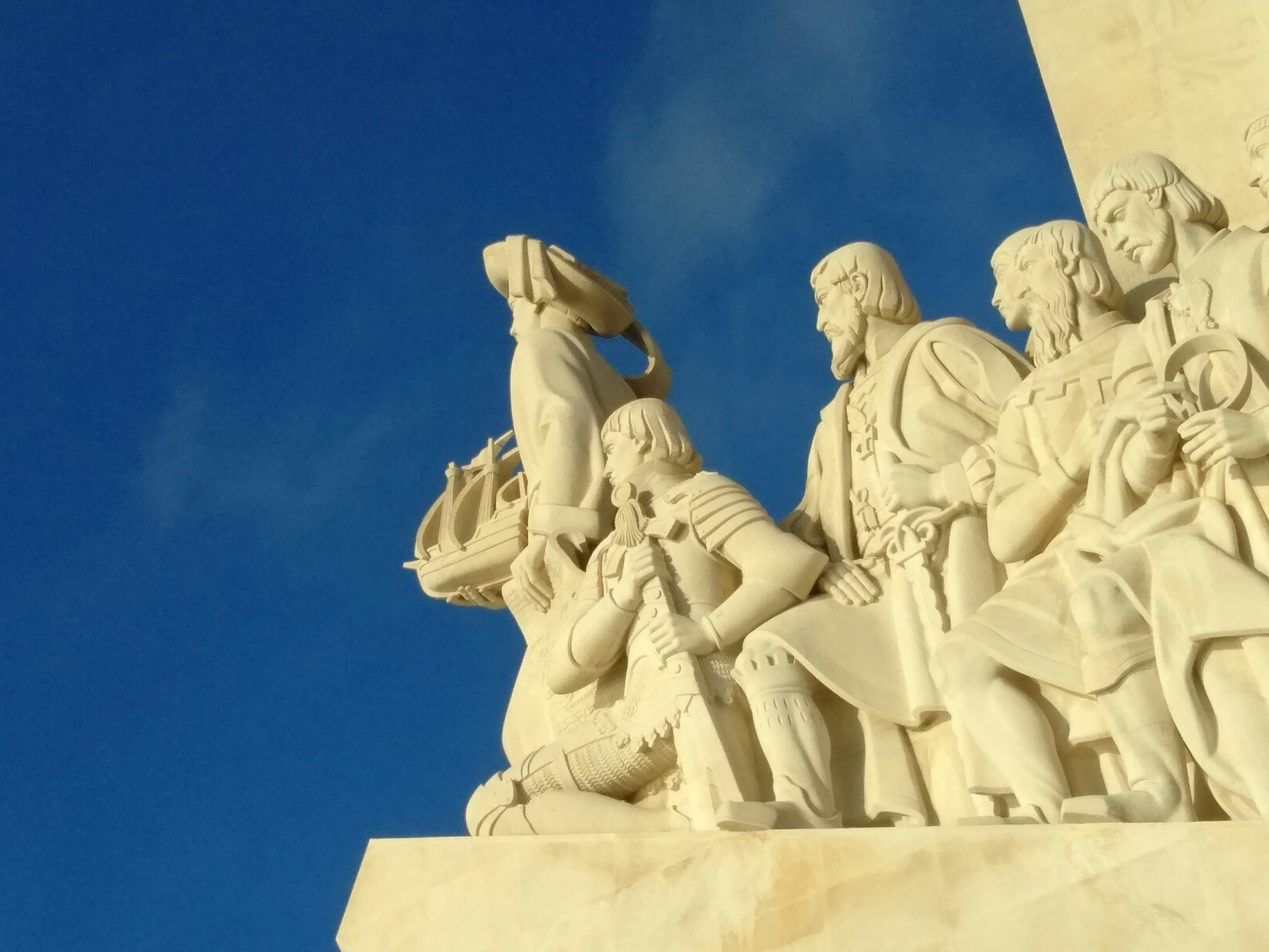 a statue of a group of people with a sky background