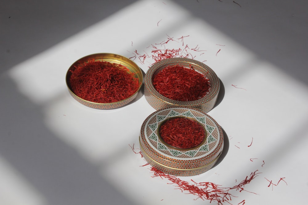 three bowls filled with red dye on top of a table