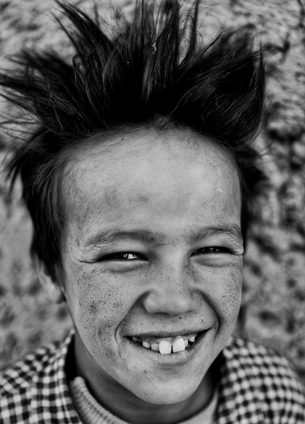 a black and white photo of a boy with a mohawk