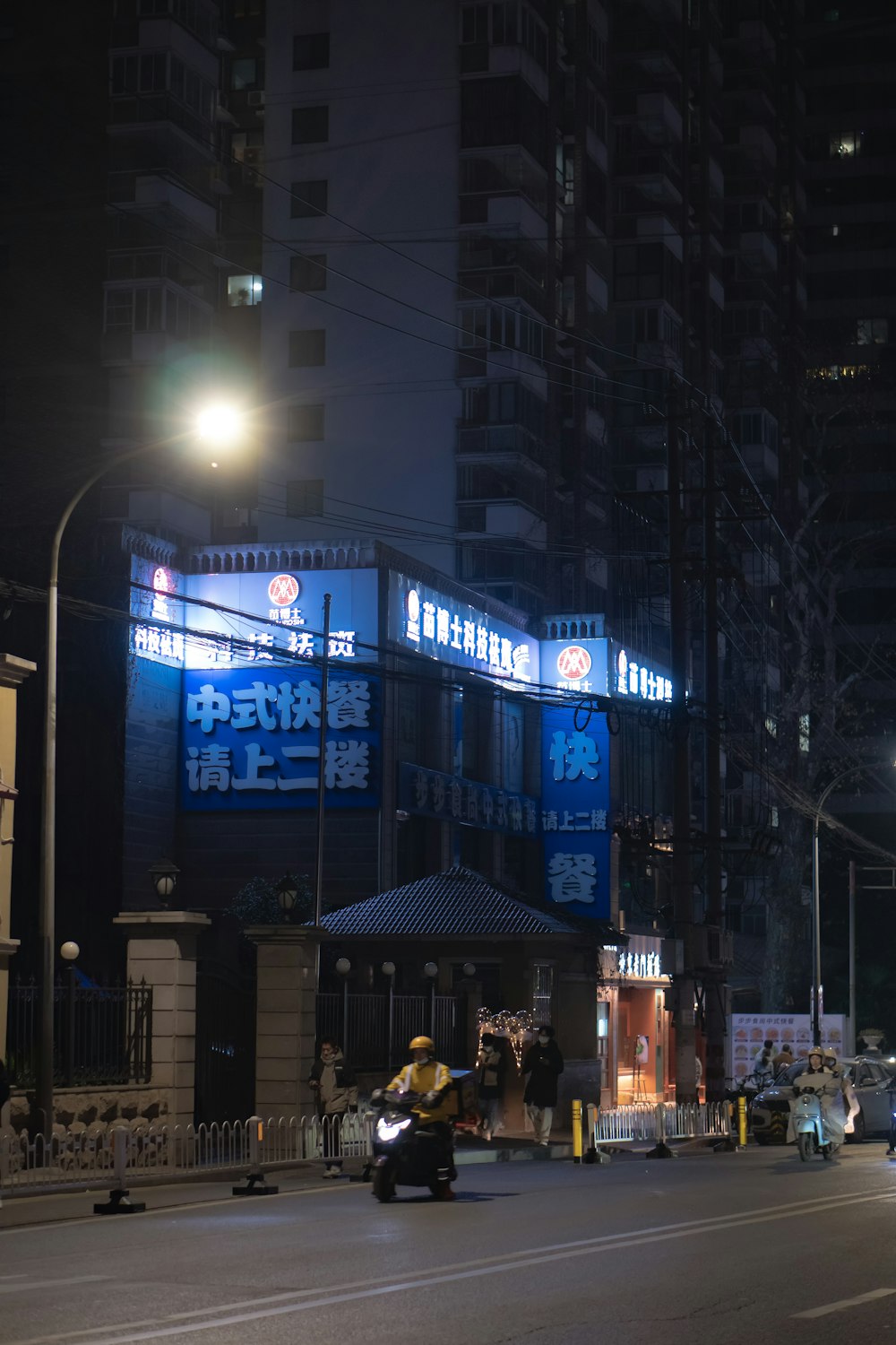 a motorcycle driving down a street next to tall buildings