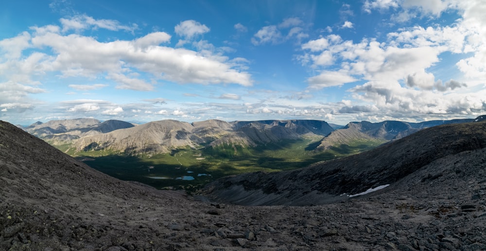 a view of a mountain range from the top of a hill