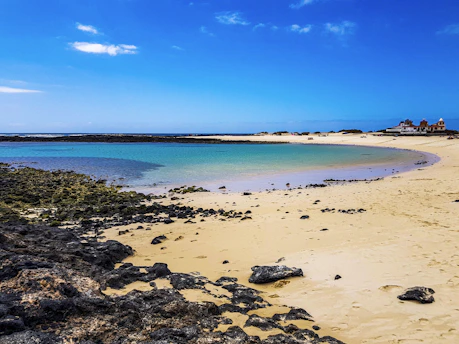 a sandy beach next to a body of water