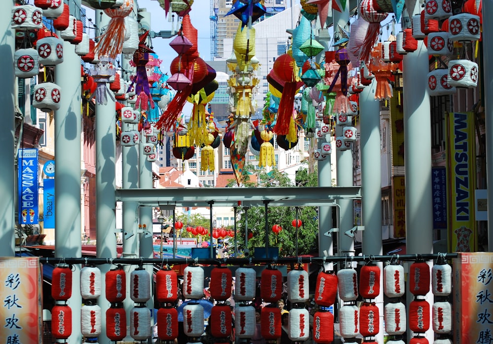 a bunch of red and white lanterns hanging from the side of a building