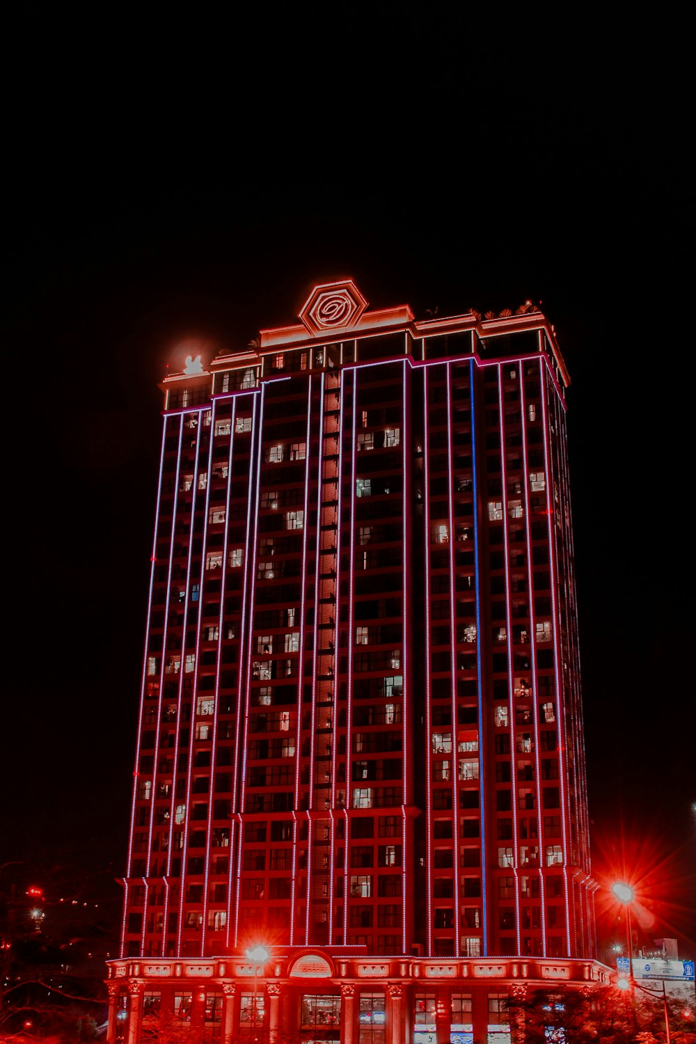 Ein hohes Gebäude mit rotem und blauem Licht beleuchtet