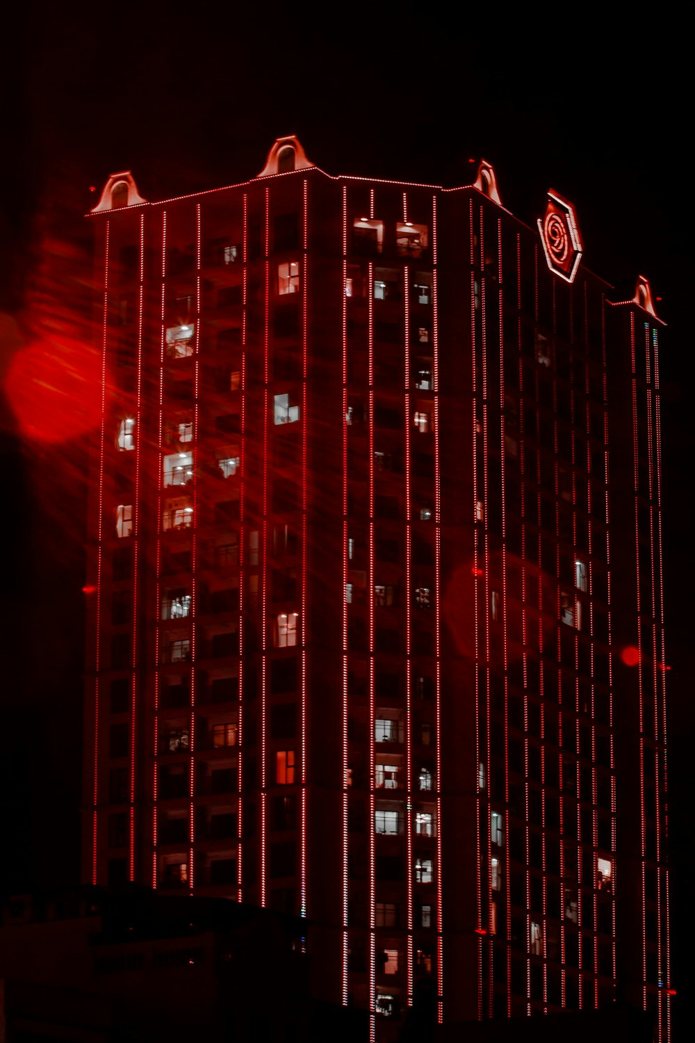 Ein hohes Gebäude mit roten Lichtern beleuchtet