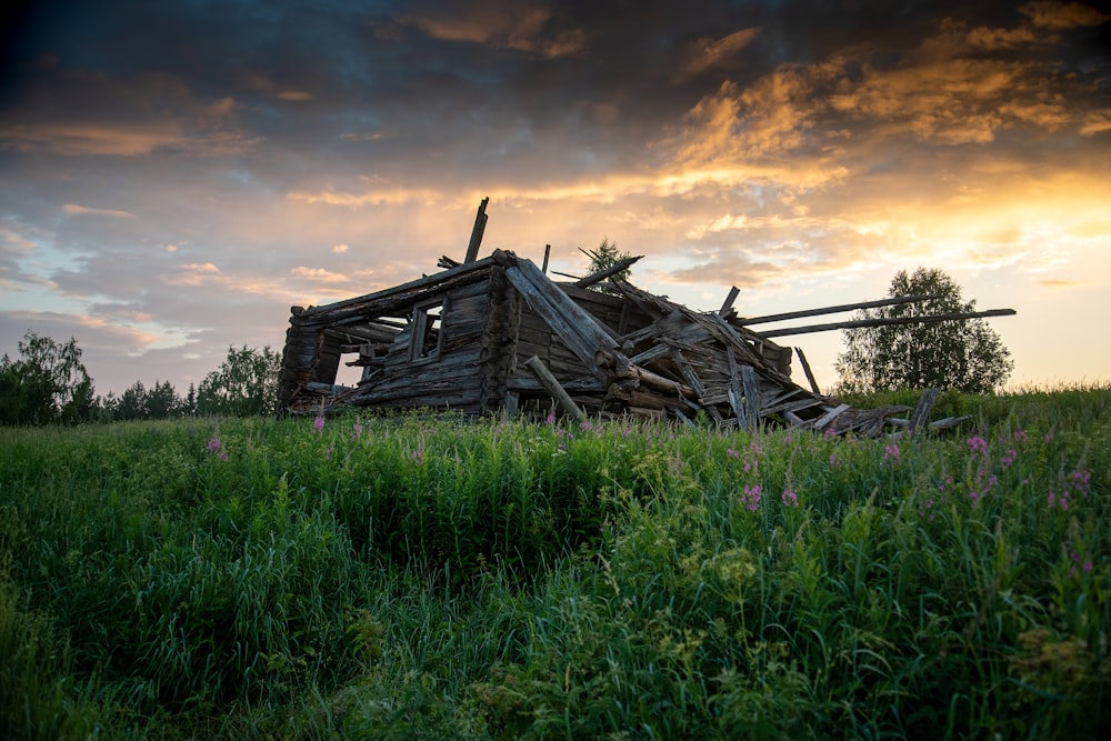 a wooden structure sitting on top of a lush green field