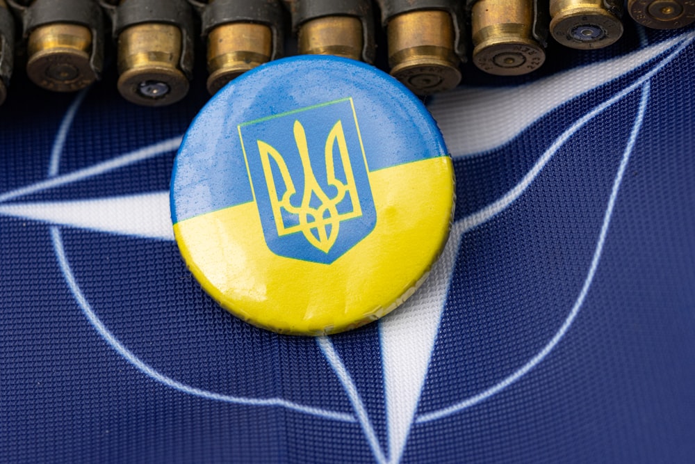 a blue and yellow button sitting on top of a table