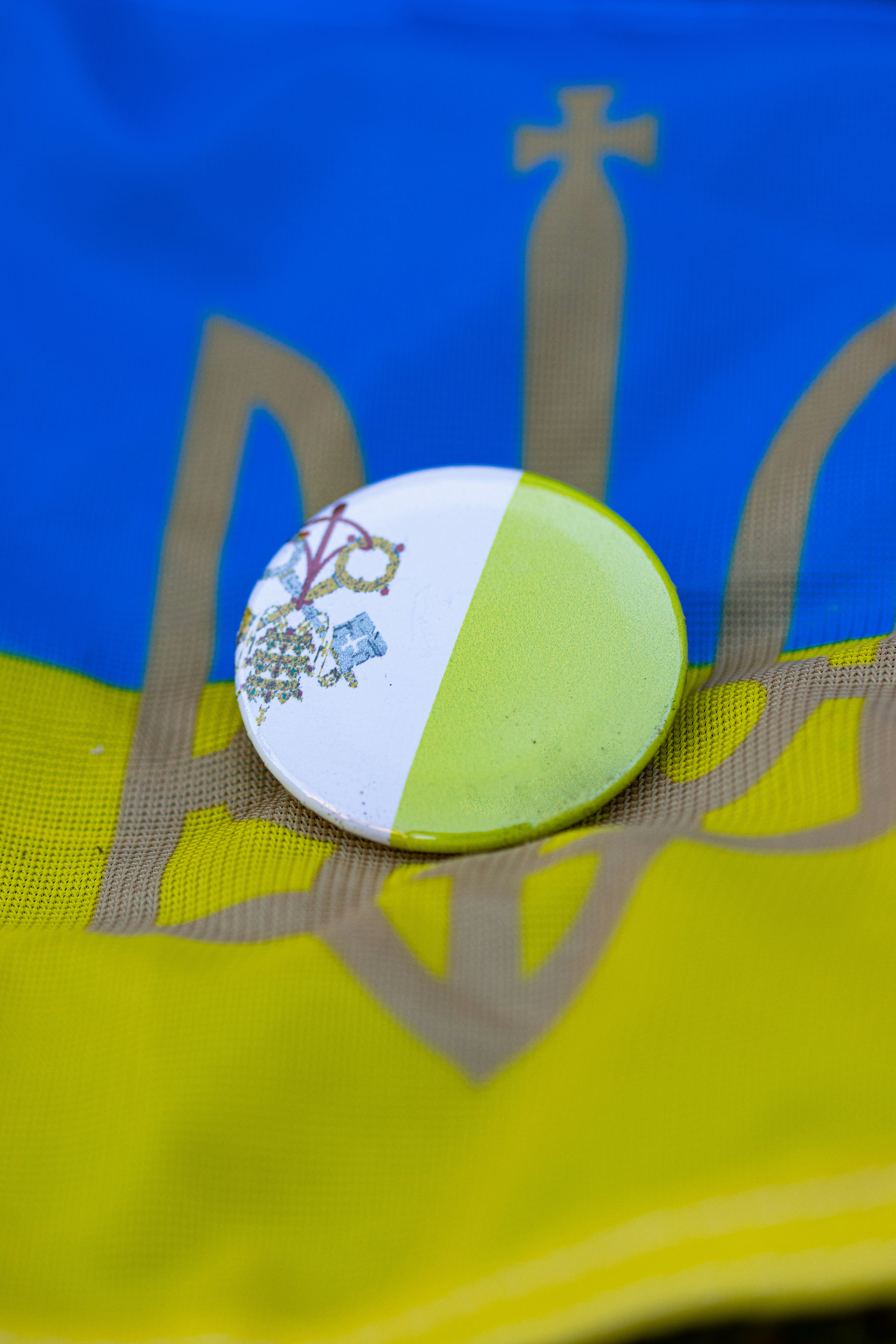 a close up of a button on a yellow and blue jacket