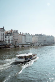 a boat traveling down a river next to tall buildings