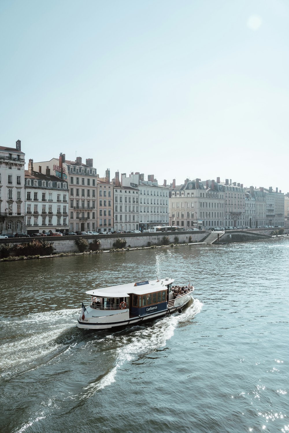 a boat traveling down a river next to tall buildings