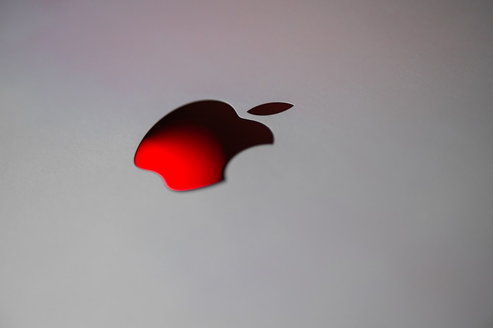 a close up of an apple logo on a white surface