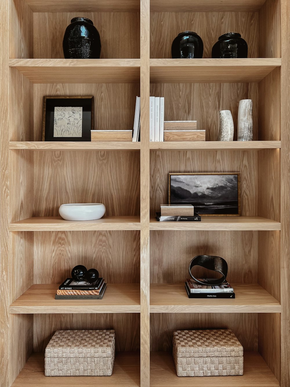a wooden shelf filled with books and vases
