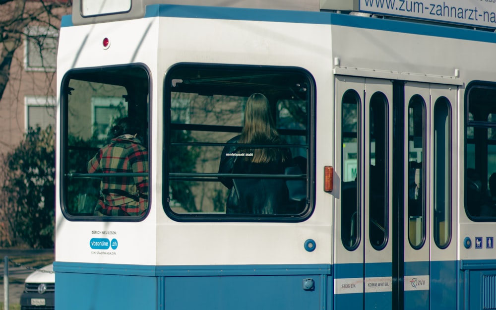 a blue and white bus driving down a street