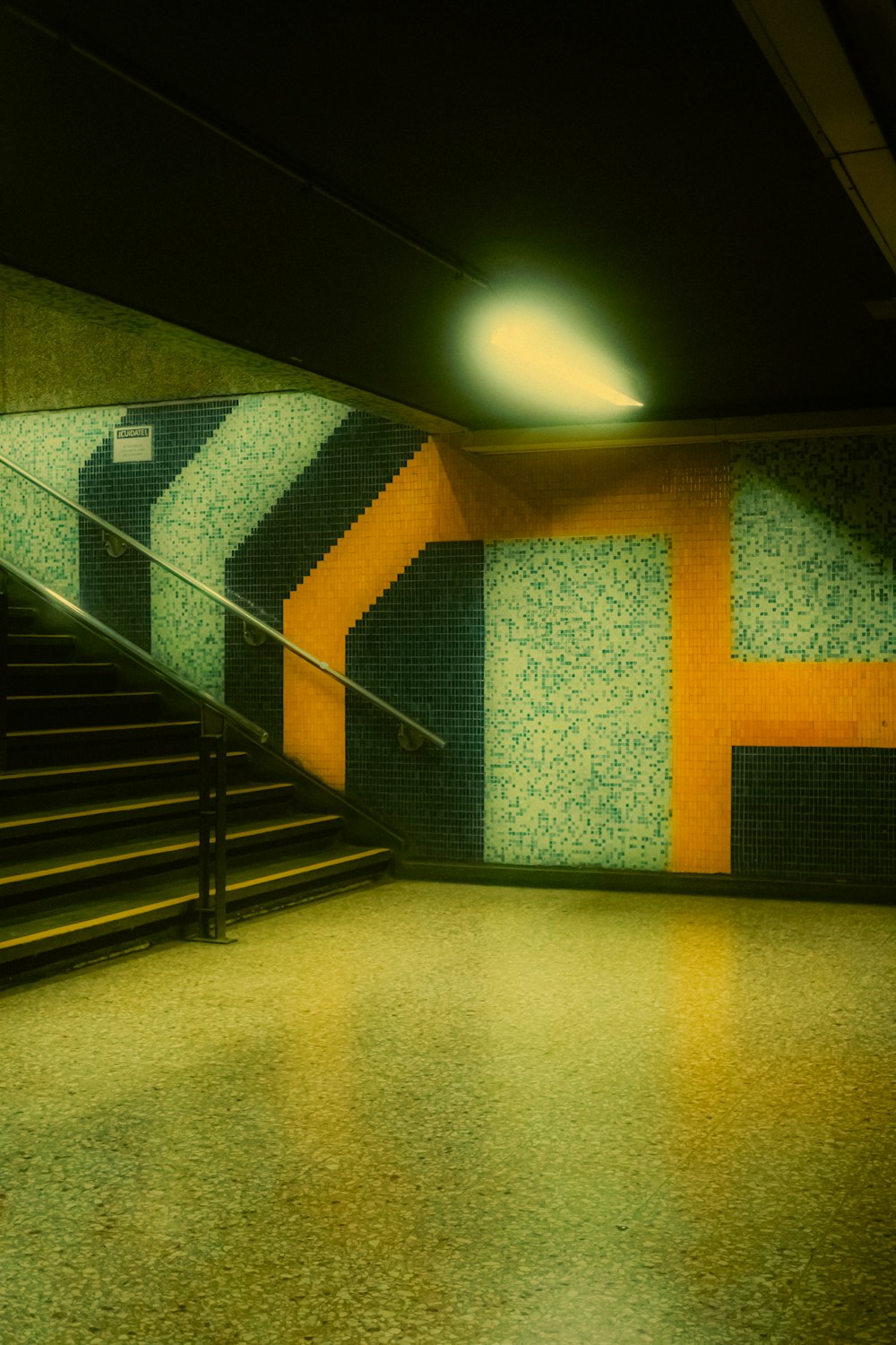 a staircase in a subway station with tiled walls