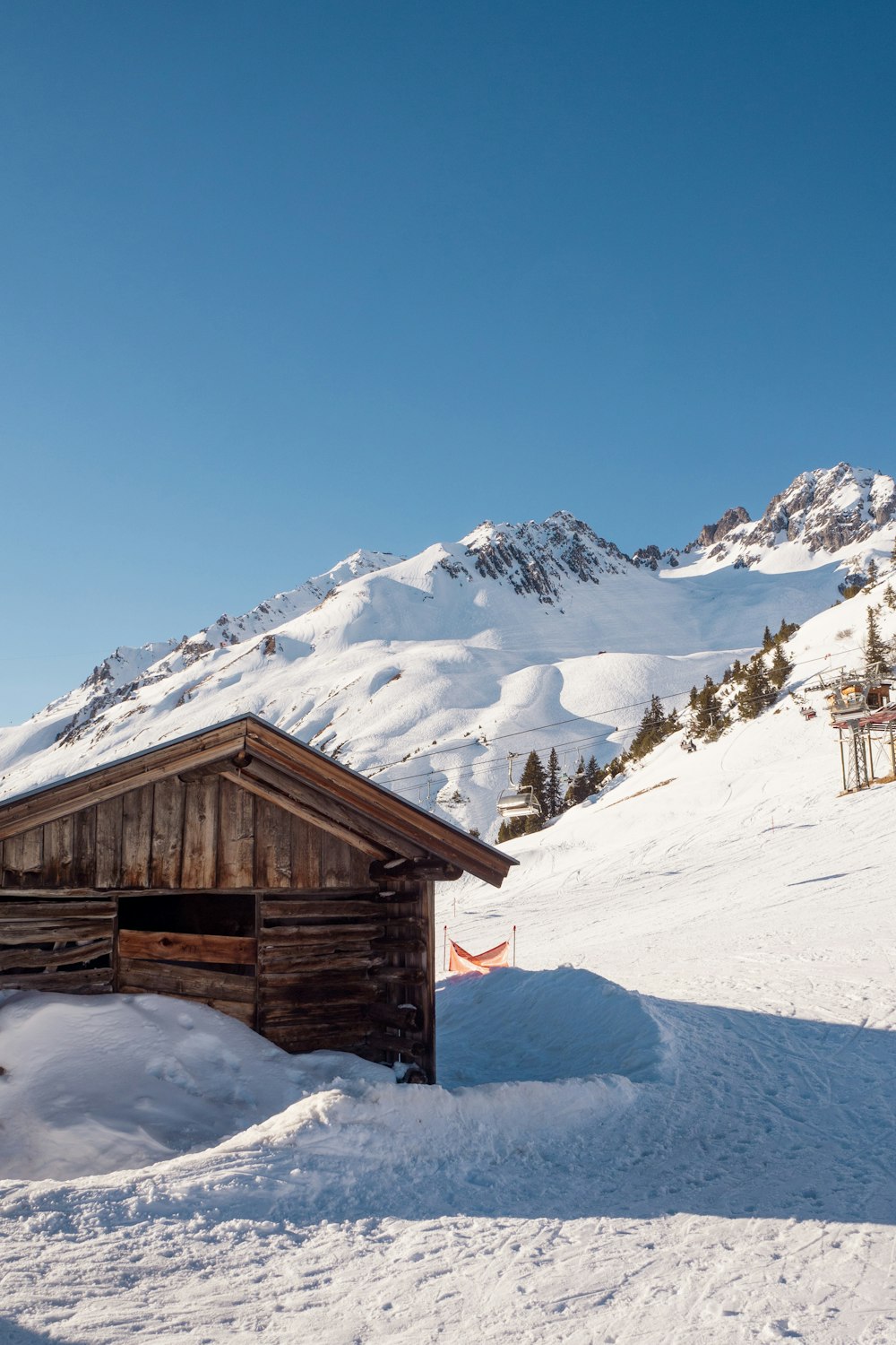 a cabin in the snow with a mountain in the background