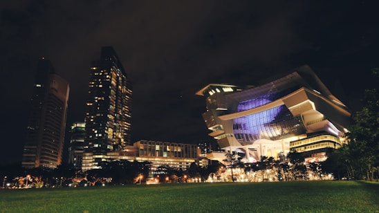 Futuristic smart building facade illuminated at night with sleek robotic service units in the foreground.