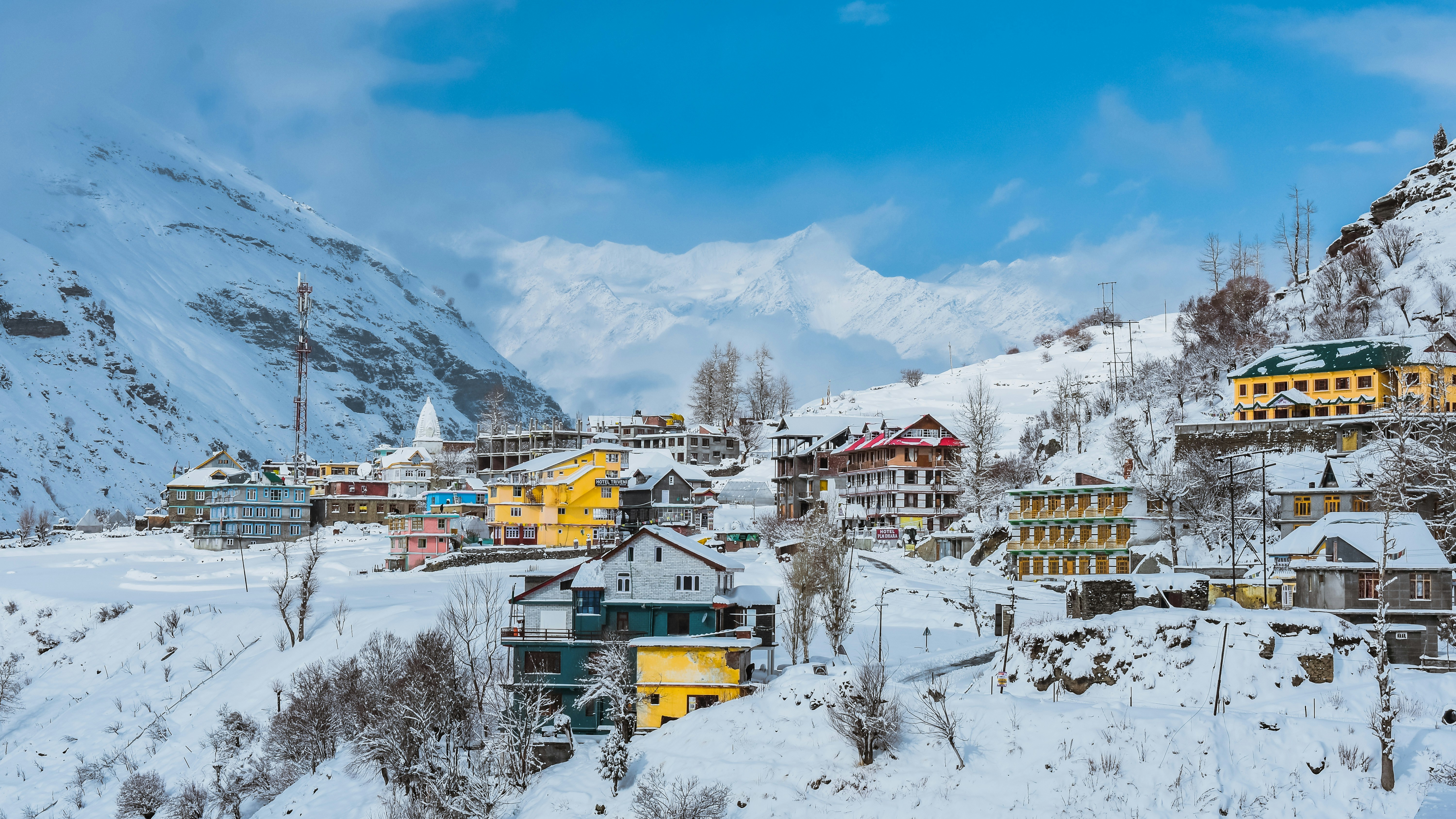 a snow covered mountain with a village in the foreground