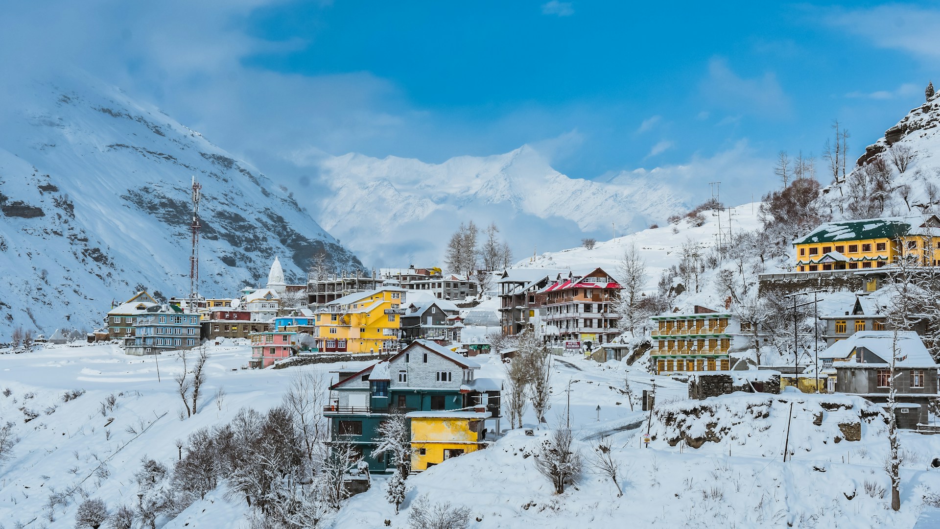 a snow covered mountain with a village in the foreground