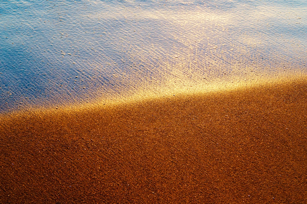 a sandy beach next to a body of water