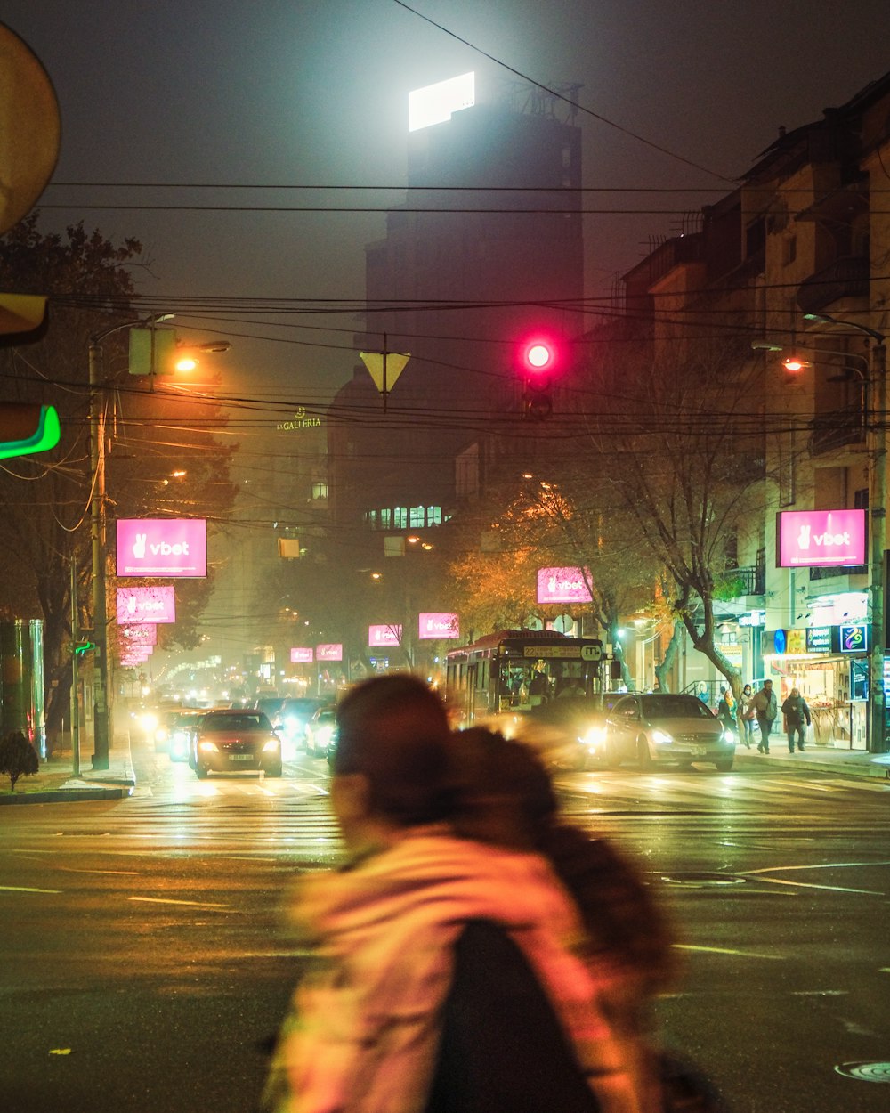 a person walking across a street at night