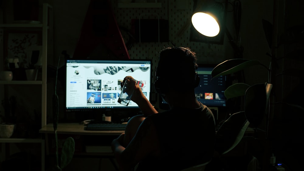 a person sitting in front of a computer screen