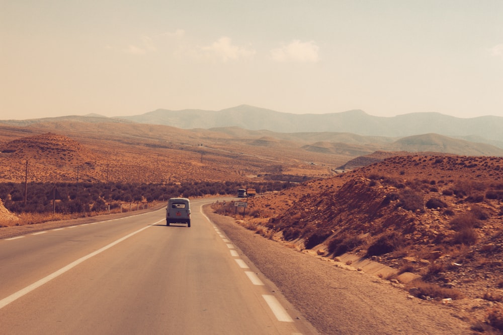 a truck driving down a road in the desert