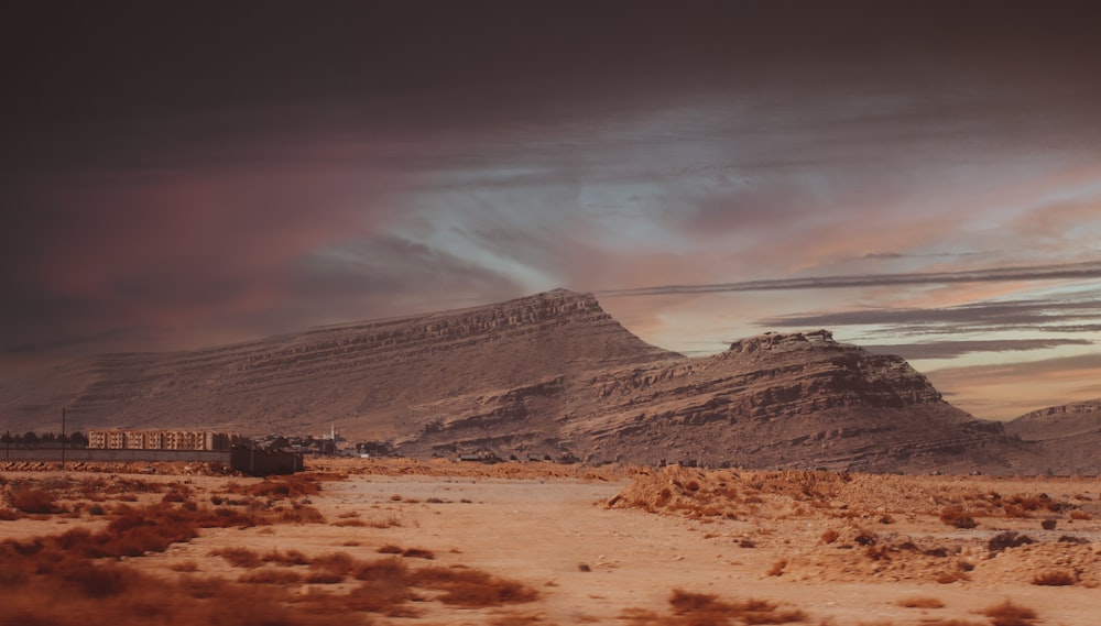 a train traveling through a desert under a cloudy sky