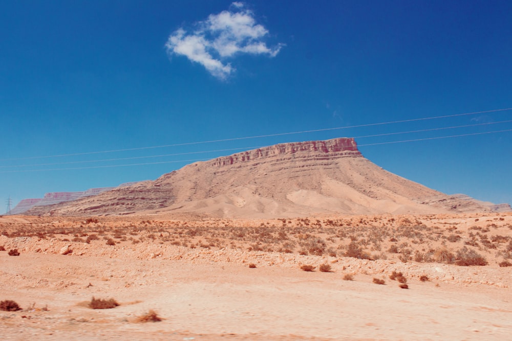 uma paisagem do deserto com uma montanha no fundo