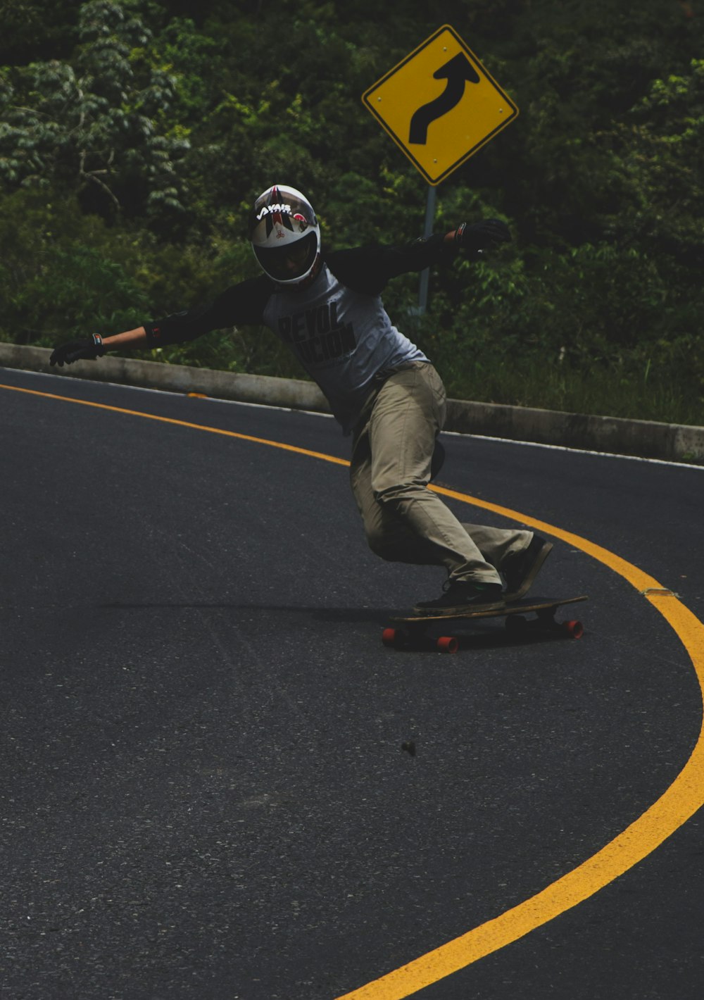 a man riding a skateboard down a curvy road