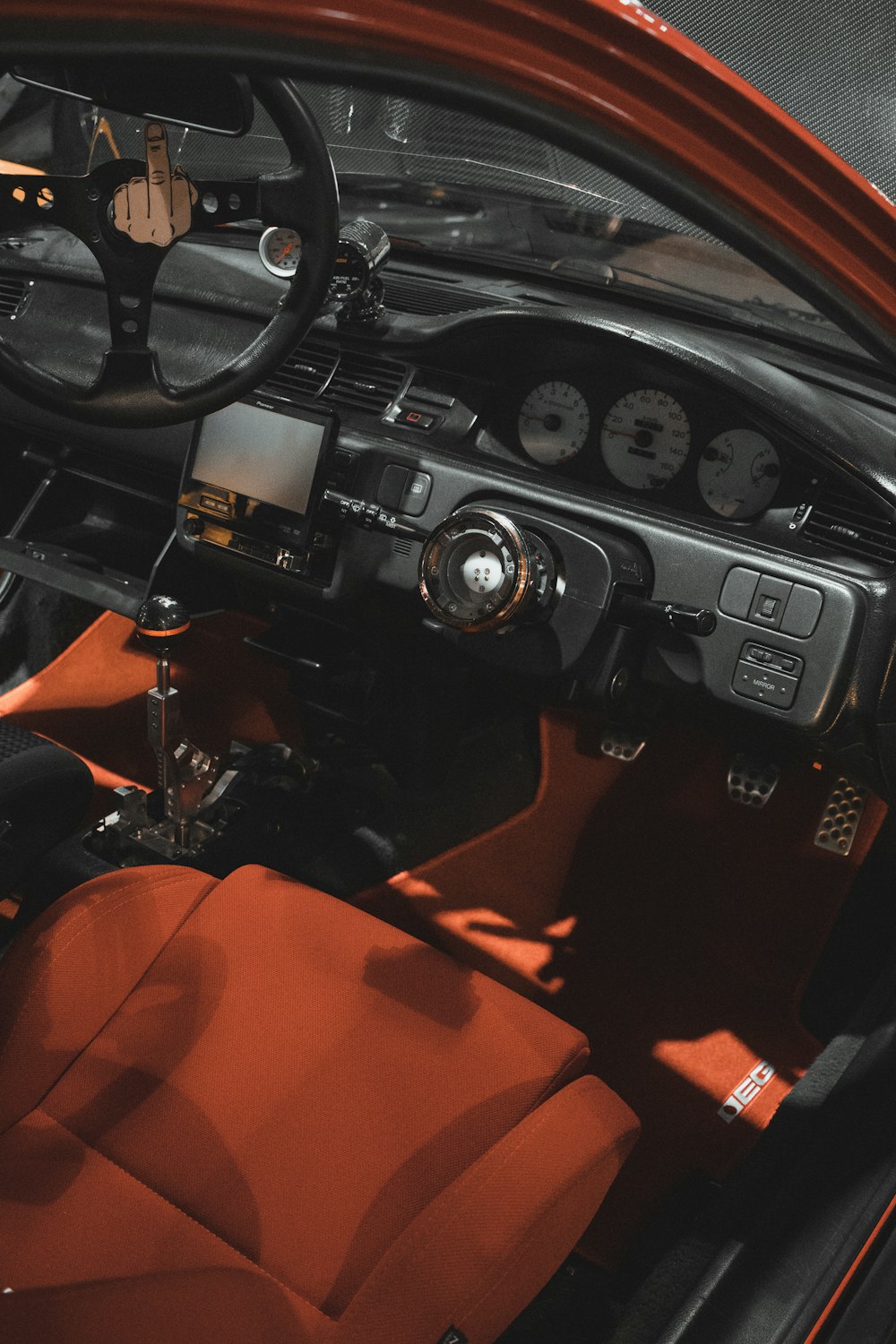 the interior of a car with a red leather seat