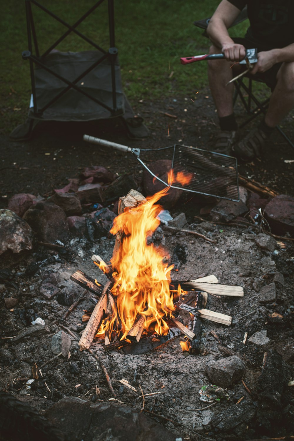 a campfire with a person sitting next to it