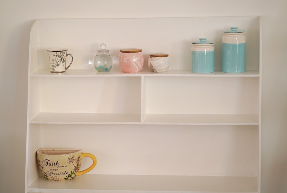 a shelf with a cup and mugs on it