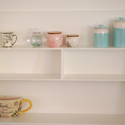 a shelf with a cup and mugs on it