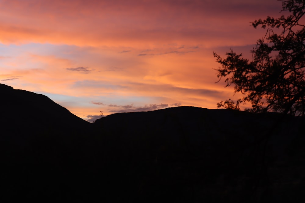 the sun is setting over a mountain range