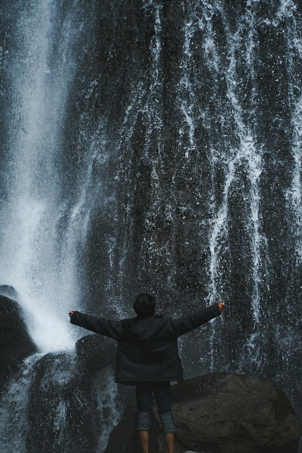 a person standing in front of a waterfall