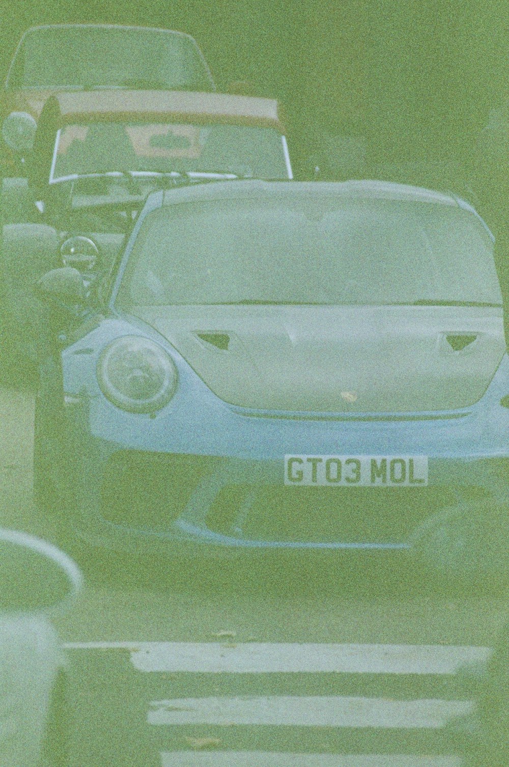 a blue sports car driving down a street