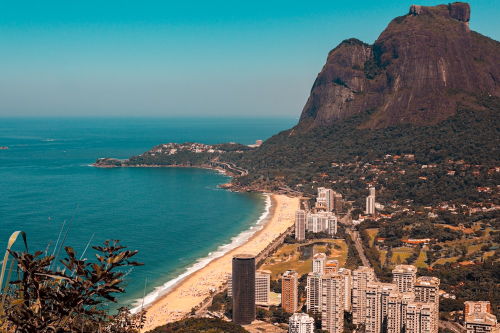 a view of a beach and mountains from a hill