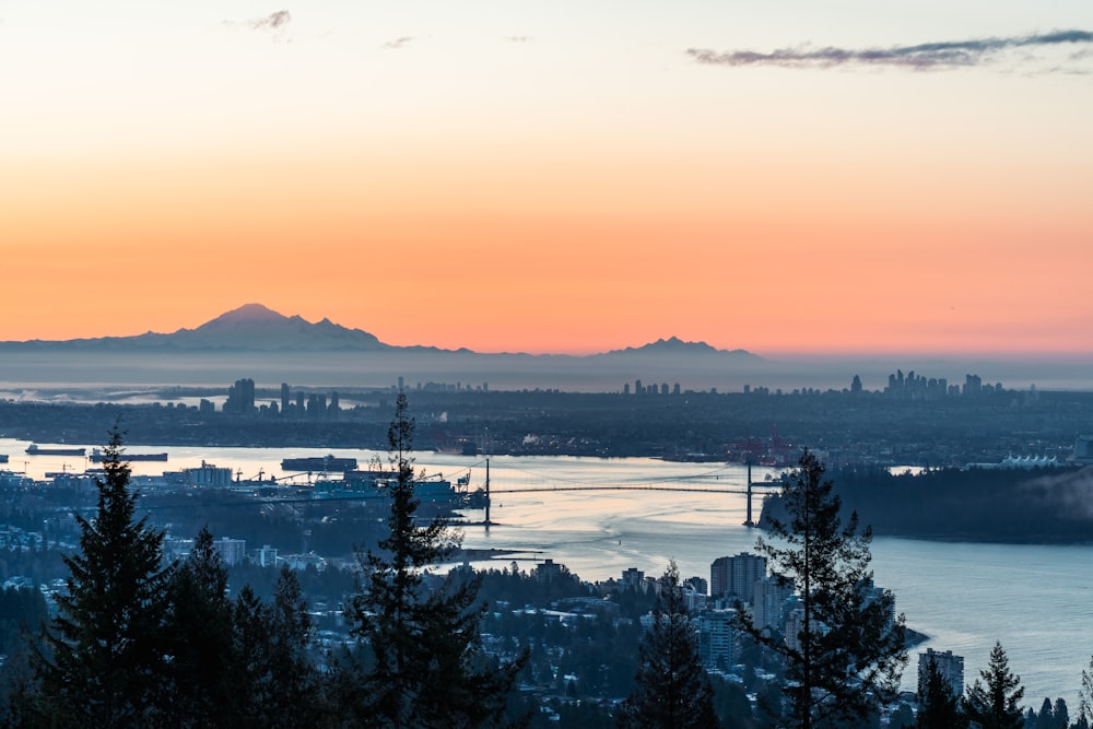 a sunset view of a city and a body of water