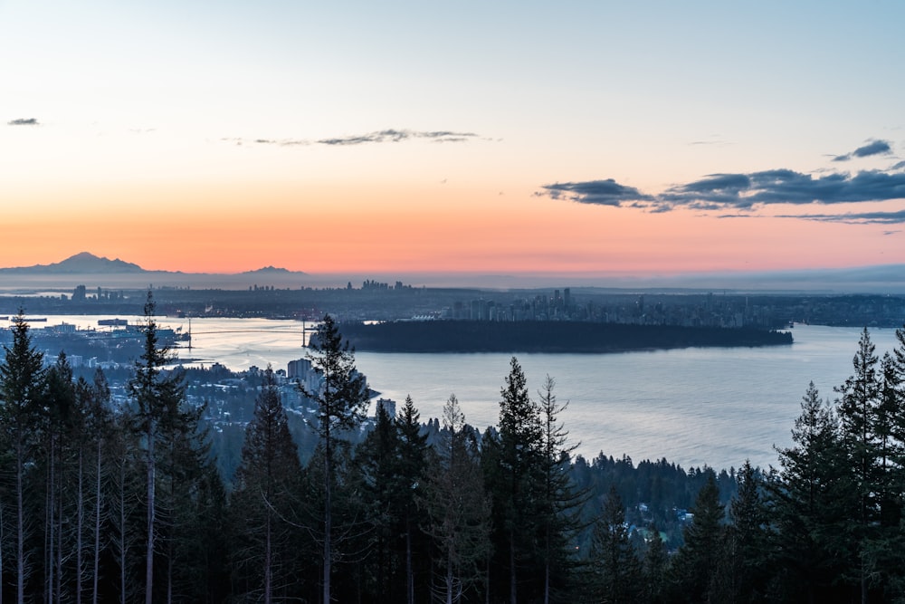 a sunset view of a city and a lake