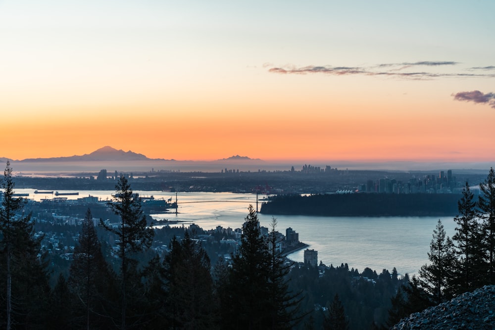 a sunset view of a city and a body of water