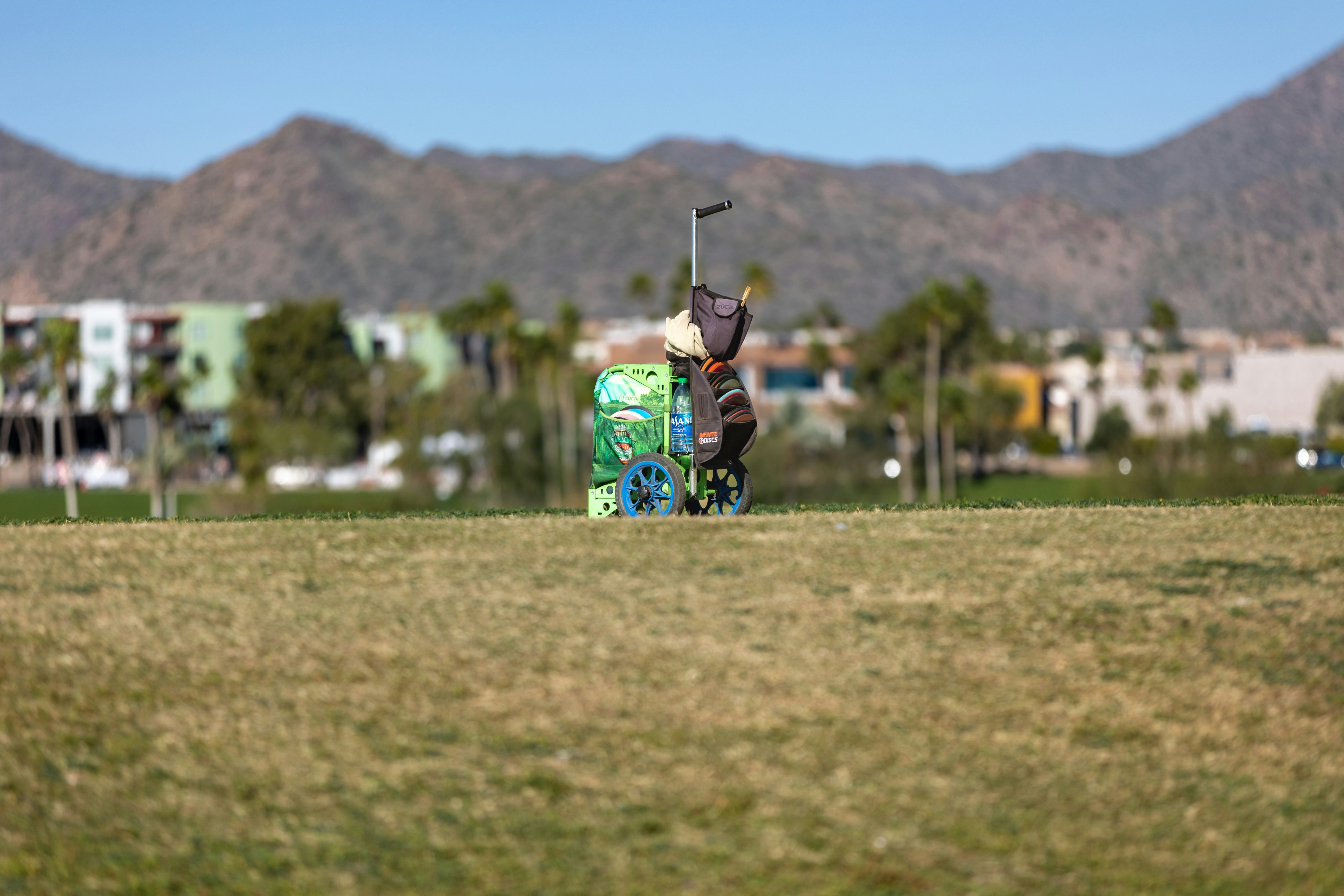 a man holding a golf club on top of a green field
