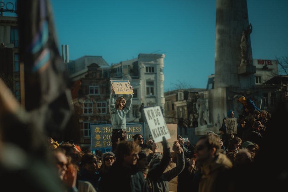 a crowd of people holding signs and flags