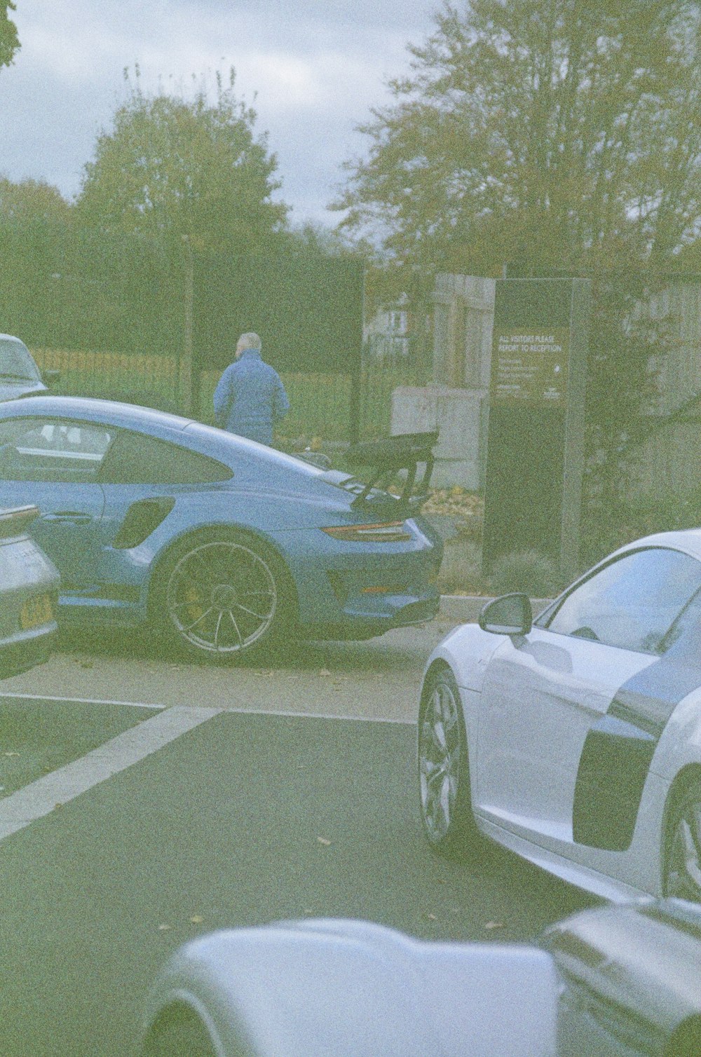 a man standing next to a blue sports car