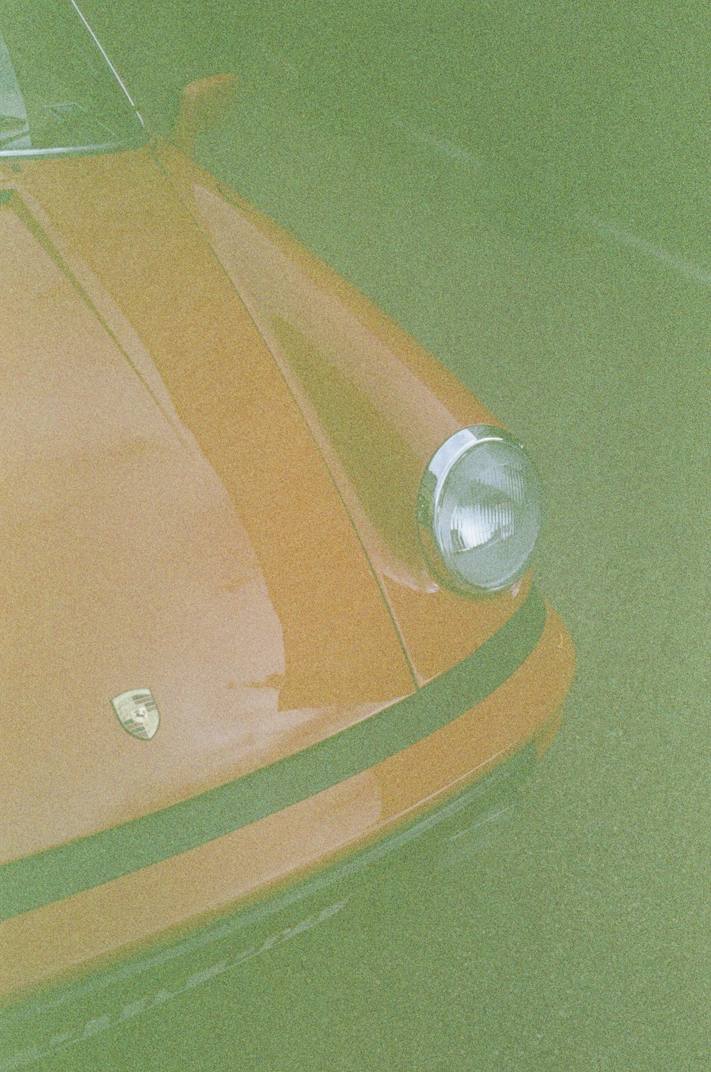 a close up of the front end of an orange sports car