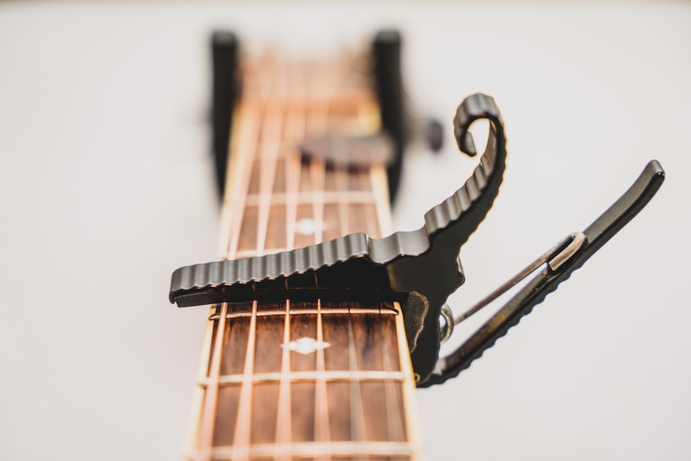 un primo piano del manico di una chitarra con un paio di forbici