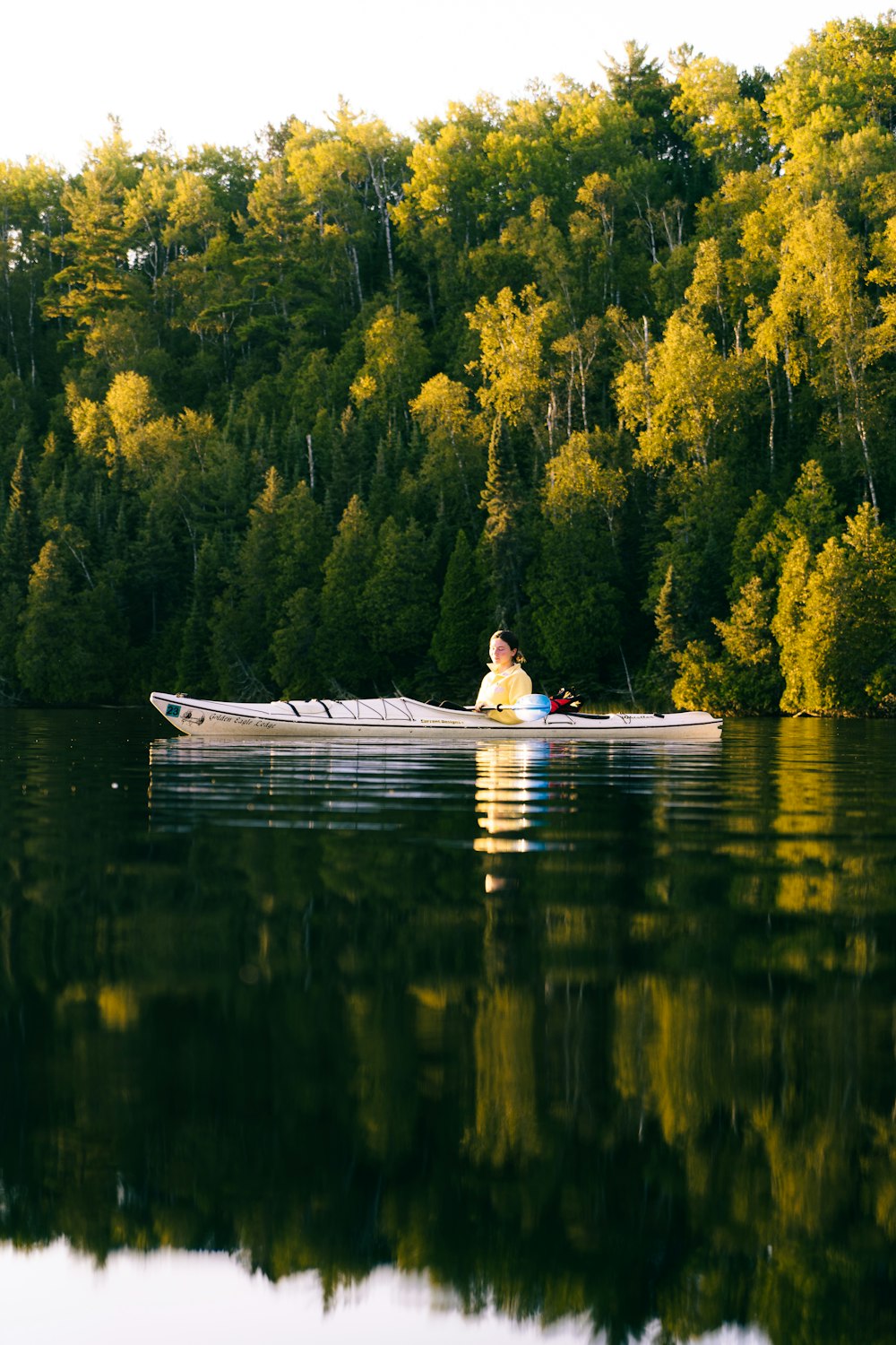 a man is paddling a canoe on a lake