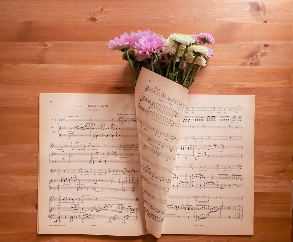 a sheet of music with flowers on top of it