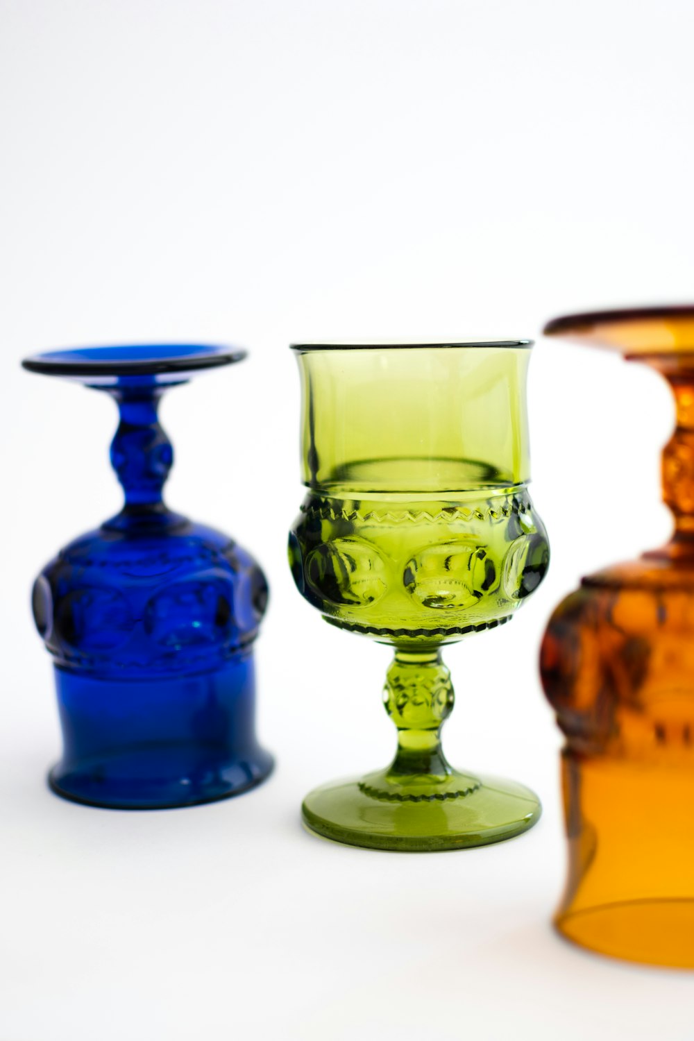 a group of three glass vases sitting next to each other