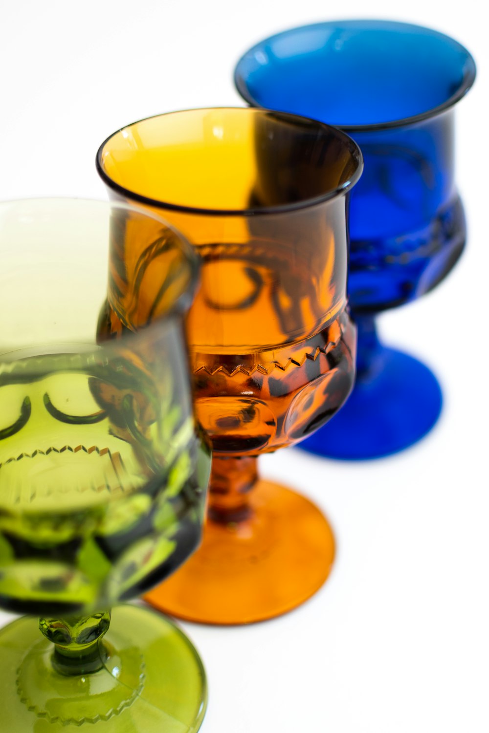 a row of colorful glass cups sitting next to each other